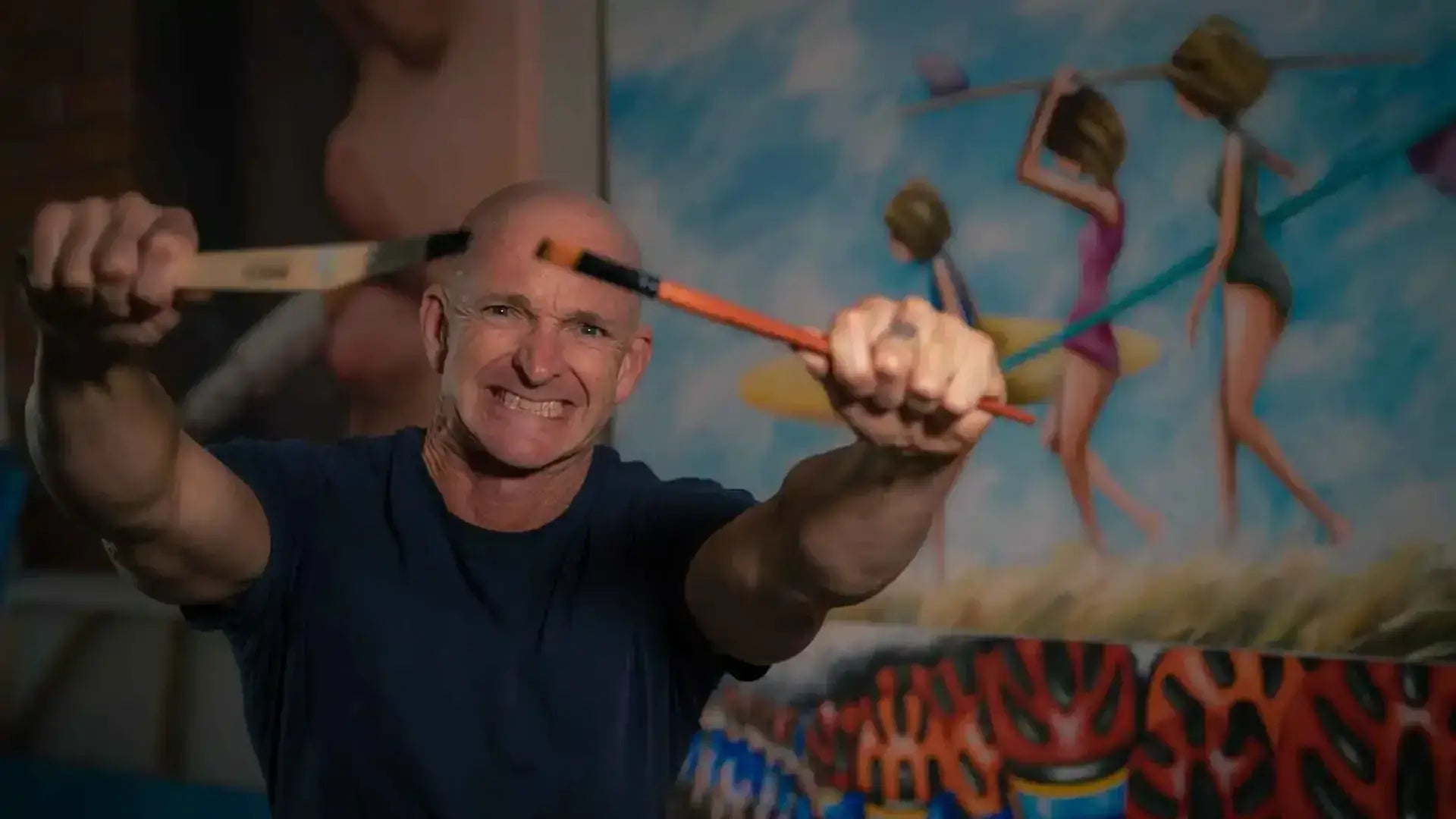 Man holding a bow and arrow in front of a colorful mural