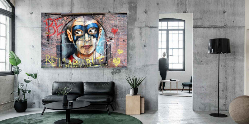 Modern living room with a large mural of a face on the wall, featuring graffiti-style text and colorful design.