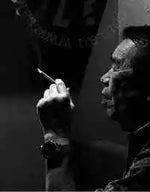 Black and white photo of a person holding a cigarette