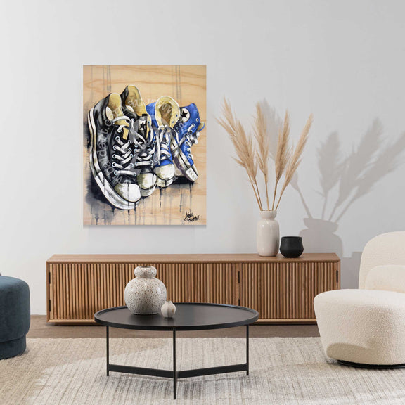 Living room with a painting of sneakers on the wall, a coffee table, and decorative items.