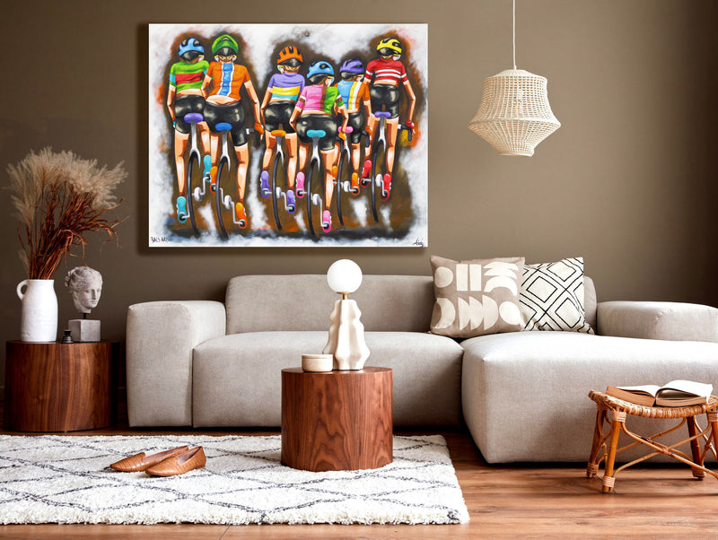 Stylish living room with vibrant bicycle wall art by Bald Art, depicting six cyclists riding together in bright jerseys from The Cycle Series.