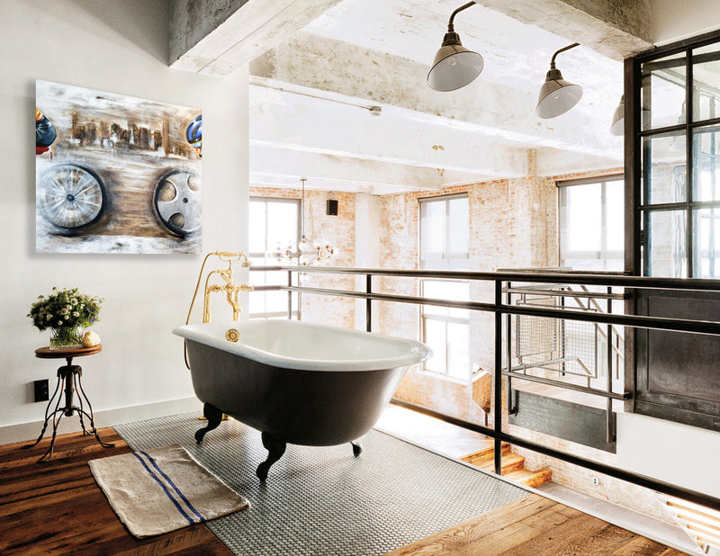 Contemporary bicycle wall art by Bald Art displayed above a freestanding bathtub in an industrial-style loft bathroom, featuring abstract bicycle wheel design from The Cycle Series.