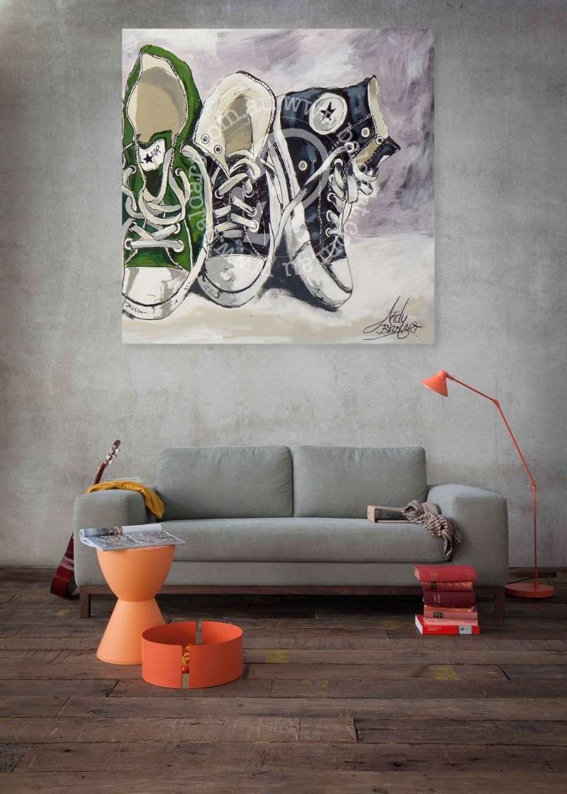 Living room with a painting of sneakers above a gray sofa.