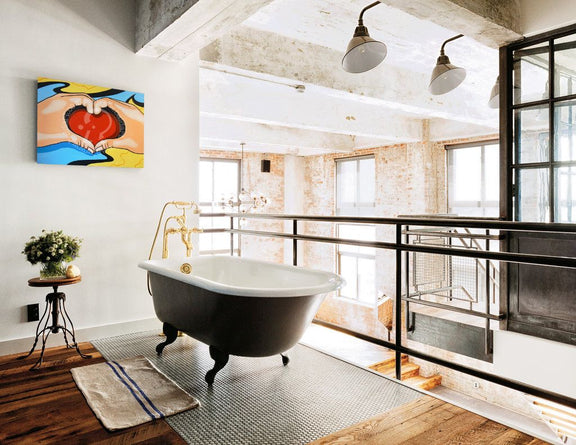 Modern bathroom with freestanding bathtub, large windows, and colorful artwork on wall.