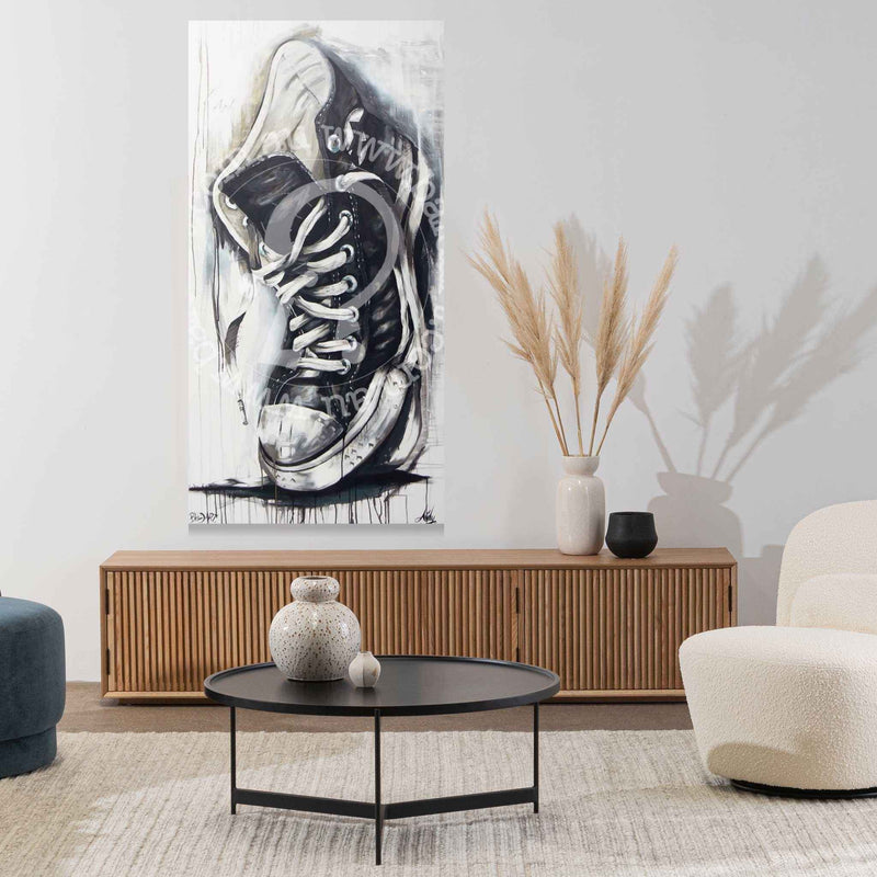 Modern living room with a large black and white sneaker artwork on the wall.