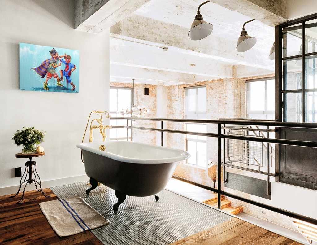 Modern bathroom with freestanding bathtub, large windows, and decorative elements.