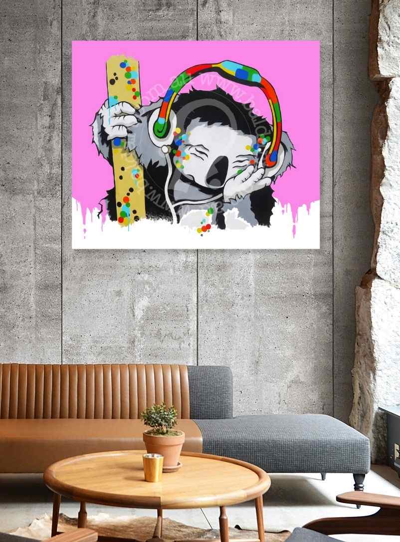 Colorful abstract painting of a face with headphones on a pink background, displayed in a modern living room.