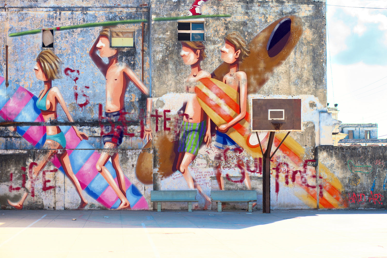 A basketball court adorned with a colorful mural showcasing individuals in dynamic poses and interactions.