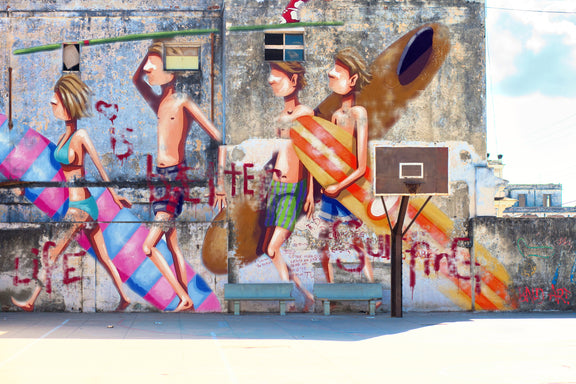A basketball court adorned with a colorful mural showcasing individuals in dynamic poses and interactions.