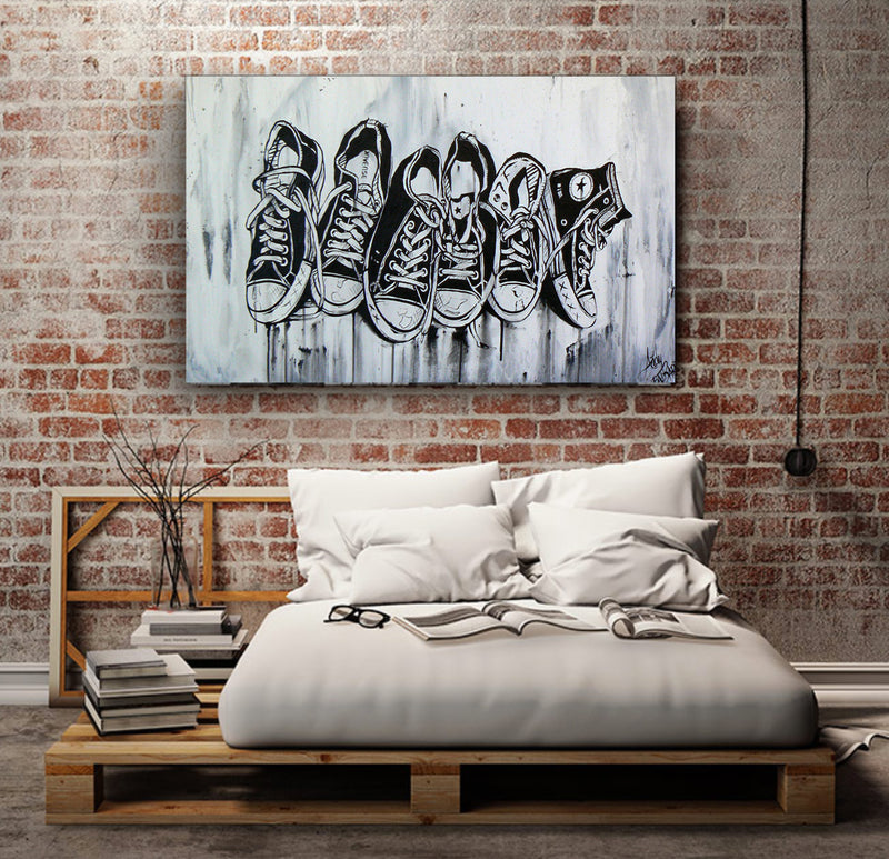 A cozy bed positioned beneath a vibrant painting on the wall.