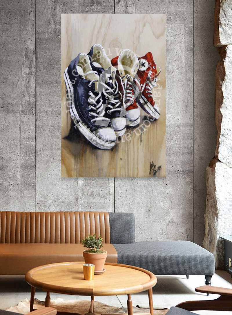 Canvas print of sneakers on a wooden background in a living room setting.