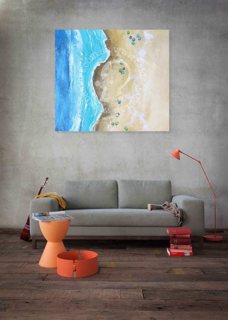 Living room with a gray sofa, orange side table, and lamp, featuring a beach scene painting on the wall.