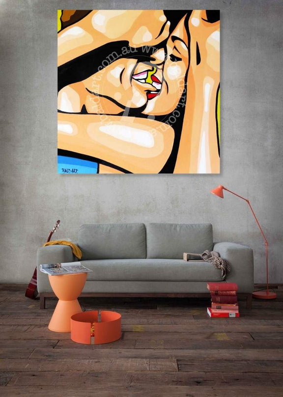 Abstract painting of a woman's face on a wall above a gray sofa in a living room.