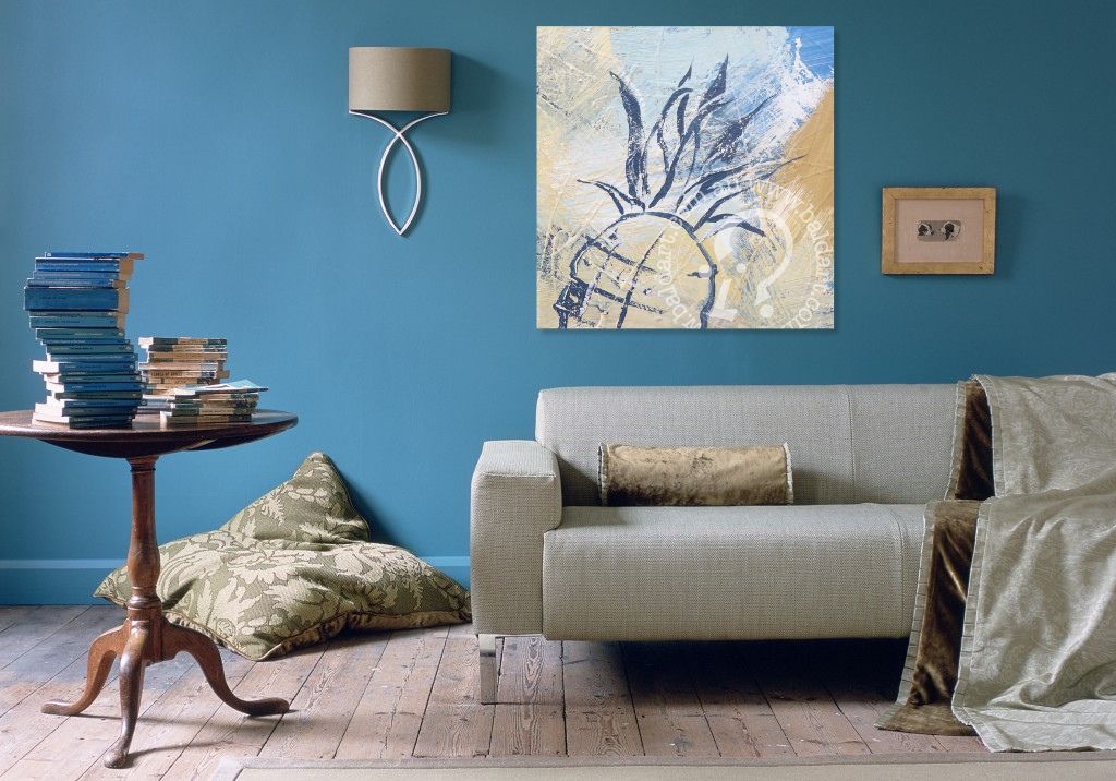 Living room with a gray sofa, wooden side table, and abstract painting on a blue wall.