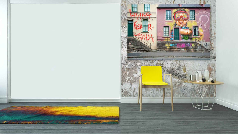 Modern interior with a yellow chair, small table, and colorful rug on a gray floor.