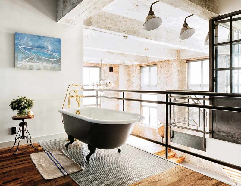 Modern bathroom with freestanding bathtub, large windows, and industrial decor.