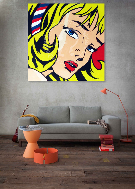 Pop art painting of a woman's face on a wall above a gray sofa in a living room.