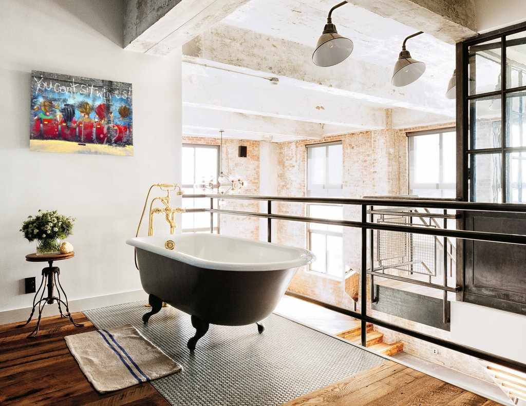 Modern bathroom with freestanding bathtub, large windows, and decorative elements.