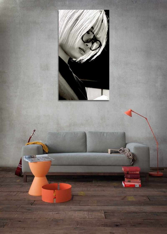 Modern living room with a gray sofa, orange coffee table, and a large black and white portrait on the wall.