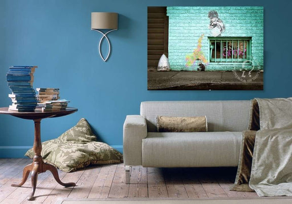 Living room with a gray sofa, wooden side table, and wall art of a mural.