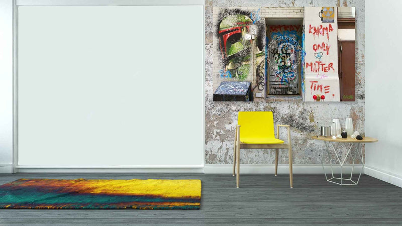 Modern interior with a yellow chair, colorful rug, and wall art.