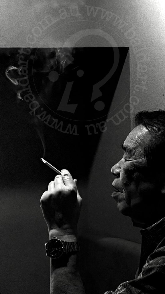 Black and white photo of a person smoking with a logo in the corner