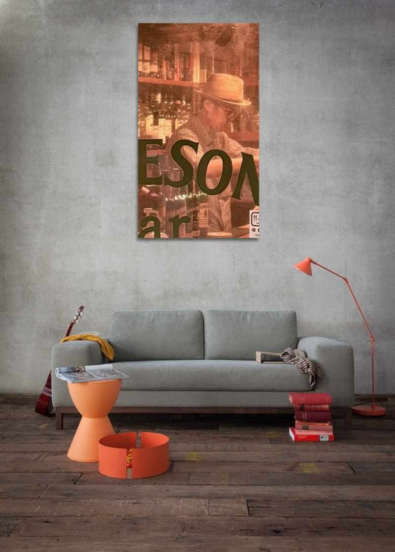 Modern living room with a gray sofa, orange side table, and a large wall art piece.