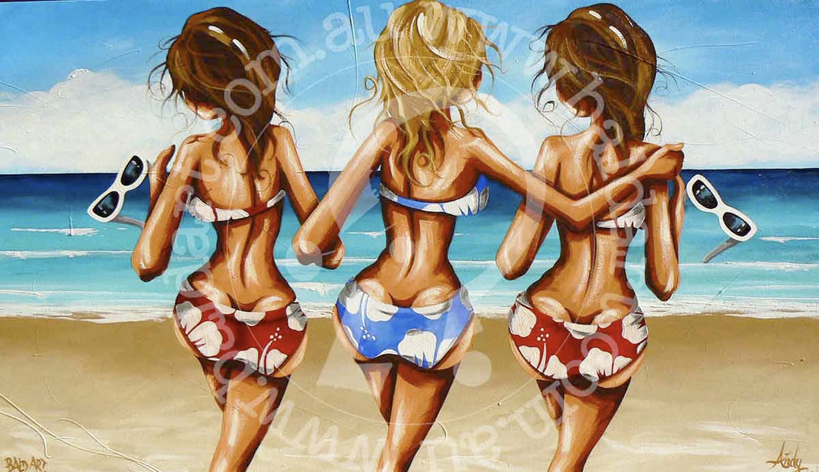 Three girls happily painting on the beach, surrounded by sand and waves, enjoying a sunny day together.