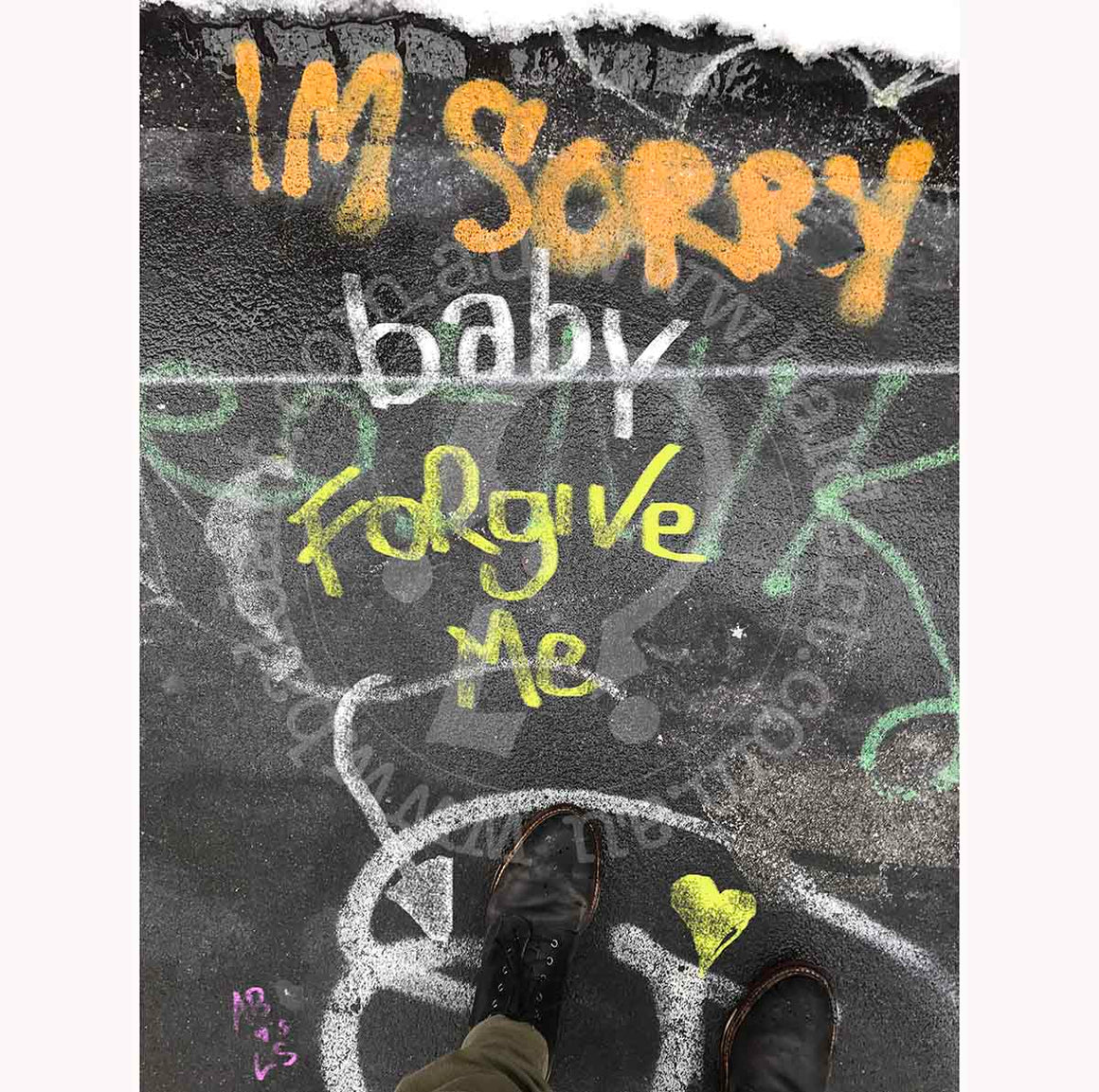 A photograph featuring a piece of contemporary urban street art with the text 'I'm sorry baby' in a stylized font, on a graffiti-covered wall.