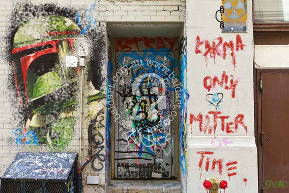 Graffiti art on a door featuring text and graphic elements in a vivid color palette, indicating themes of karma and time.