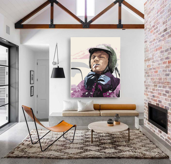A canvas print featuring a stylized portrait of a person wearing a helmet, predominantly in purple and brown tones, displayed above a contemporary living room setup.