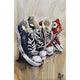 A painting of various sneakers in different colors on a wooden background, signed by the artist.