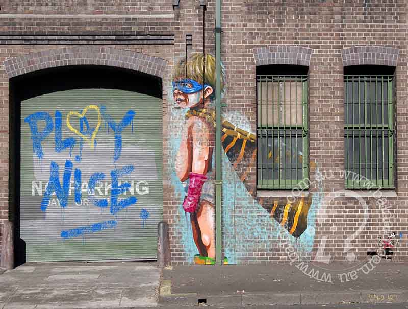 A piece of contemporary art featuring a stylized character with a heart-shaped balloon, painted on a wall with a 'PLAY NICE' text background.