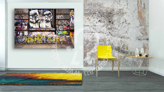 Interior view of a room with a yellow chair and a painting hanging on the wall.