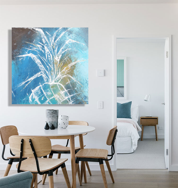 A colorful pineapple artwork adorns the wall of a chic modern dining room, enhancing the contemporary atmosphere.