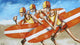 A painting featuring stylized figures representing surfers on a surfboard, with a yellow and red color scheme and a blue sky background.