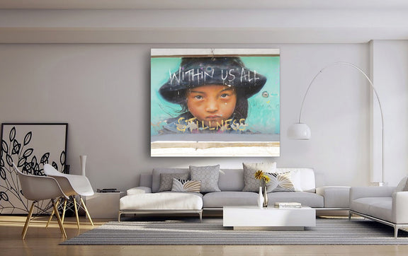 A canvas wall art featuring a stylized urban scene with text and a figure, displayed above a modern sofa setup in a minimalist interior.
