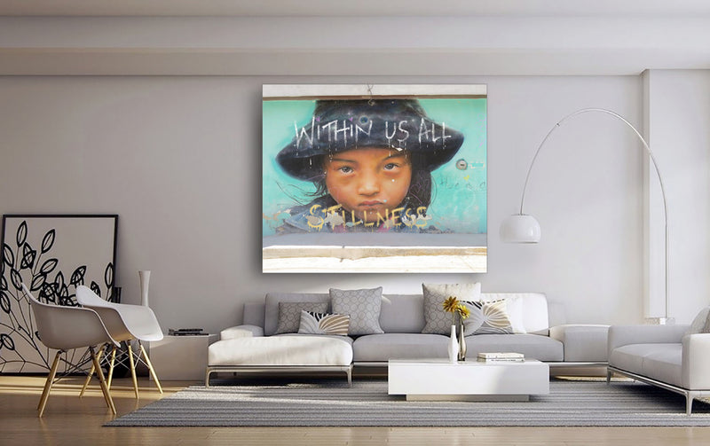 A canvas wall art featuring a stylized urban scene with text and a figure, displayed above a modern sofa setup in a minimalist interior.