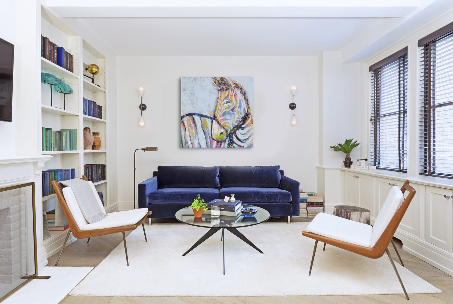 A stylish living room showcasing a vibrant painting on the wall, complemented by inviting seating and warm lighting.