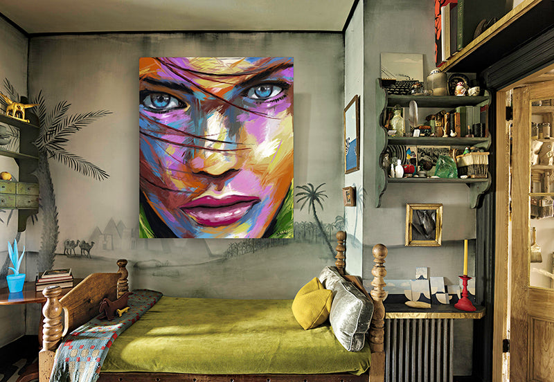 A stylish bedroom showcasing a bed, a functional desk, and an artistic painting, offering a comfortable living space.